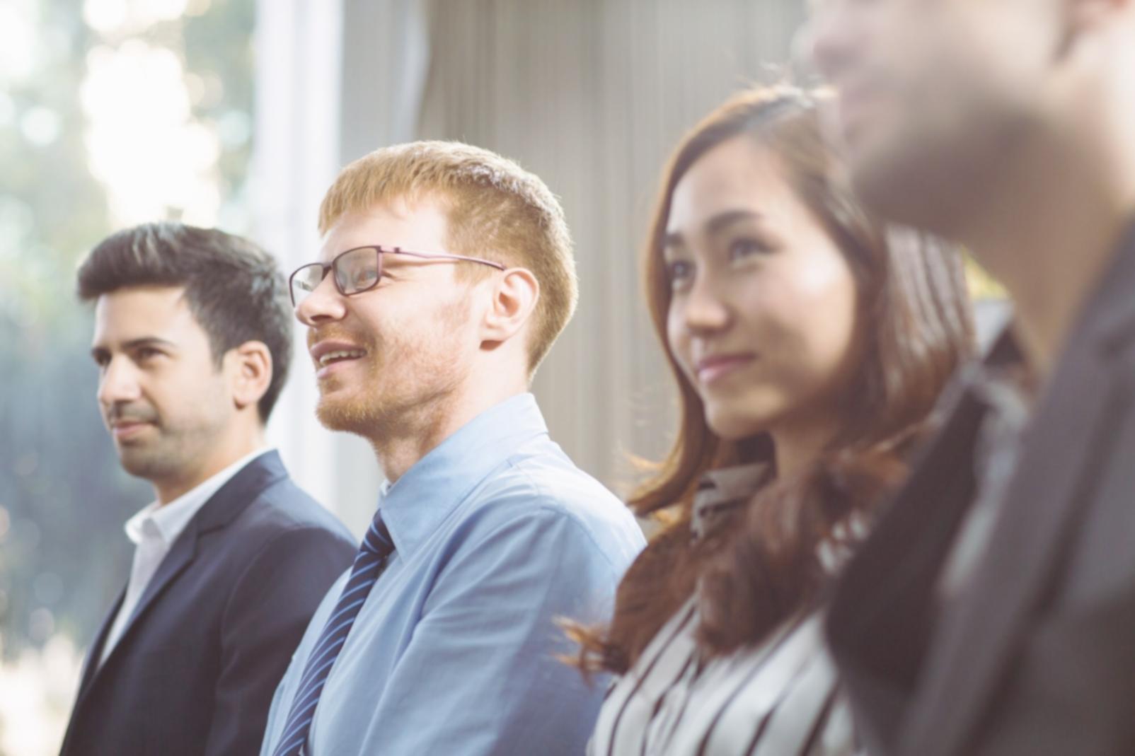 Professionnels en formation analyse financière travaillant sur des documents et tablettes